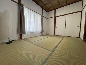 an empty room with a large window and white floors at Slowhouse HAYAMA in Hayama