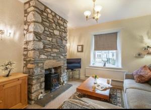 een woonkamer met een stenen open haard en een bank bij Labernum Cottage, Ingleton, Yorkshire Dales National Park, Famous Three Peaks, Near The Lake District, Pets Are Welcome in Ingleton 