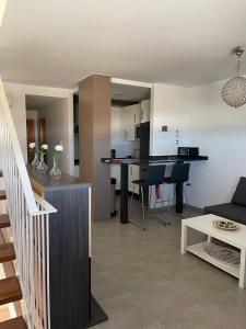 Una sala de estar y una cocina con un sofá y una mesa. en Capital Seaview, en Carboneras