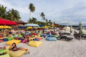 a group of people laying on the beach at Nu Melati Hotel in Pantai Cenang