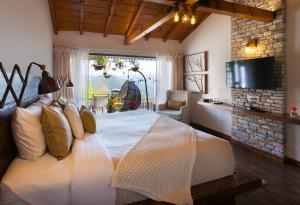 a bedroom with a large bed and a television at The Birdcage, Mukteshwar in Mukteshwar