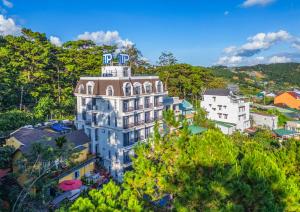 un edificio in cima a una collina con alberi di TP Dalat Hotel a Da Lat