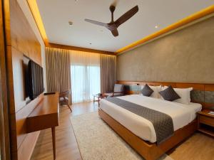 a hotel room with a bed and a television at Sterling Lontano Waterfront Wayanad in Meppādi +92 photos