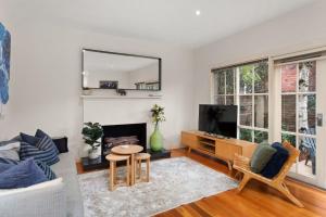 Una sala de estar con un sofá y un televisor. en Boutique Stays - Brighton Abode, en Melbourne
