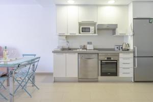 a kitchen with white cabinets and stainless steel appliances at Playa de Poniente in Benidorm