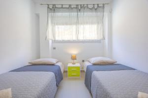 two beds in a white room with a window at Playa de Poniente in Benidorm +17 photos