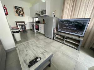 a living room with a television and a kitchen at Fischreiher Seaside Self Catering Studio Apartment in Swakopmund