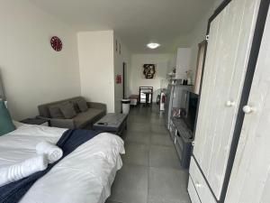 a bedroom with a bed and a living room at Fischreiher Seaside Self Catering Studio Apartment in Swakopmund