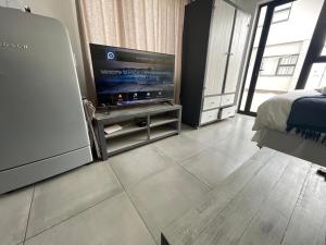 a living room with a television and a bed at Fischreiher Seaside Self Catering Studio Apartment in Swakopmund +10 photos