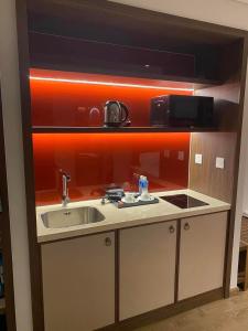 a small kitchen with a sink and a microwave at APEC MANDALA CHAMBAY Thanh La Home in Phan Thiet