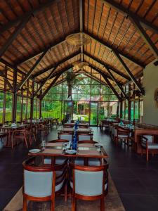 a restaurant with tables and chairs in a room at Sterling Lontano Waterfront Wayanad in Meppādi