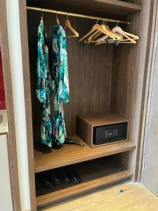 a closet with a tv and a microwave at APEC MANDALA CHAMBAY Thanh La Home in Phan Thiet