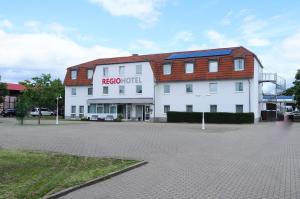 a large white building with a red roof at REGIOHOTEL Salzland Schönebeck in Frohse