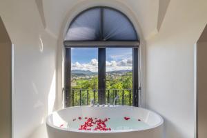 una vasca da bagno di fronte a una finestra con vista di TP Dalat Hotel a Da Lat Altre 37 foto