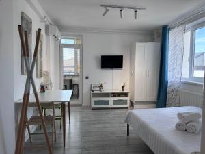 a small white room with a table and a bed at Diamant residence - self check in & free parking in Bragadiru