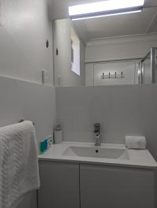 诺斯黑文Haven Waters Motel & Apartments的带水槽和镜子的白色浴室