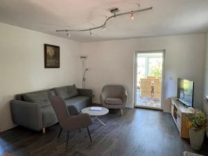 a living room with a couch and chairs and a tv at Ferienhaus Hase Bomsdorfer Hof in Gräfenhainichen