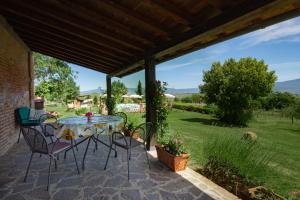 a patio with a table and chairs and a view at Agriturismo San Francesco in Cortona