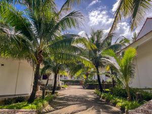 a row of palm trees in front of a building at Hawaii Resort Phu Quoc in Phu Quoc