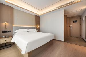 Postel nebo postele na pokoji v ubytování Poltton Grand Century Hotel