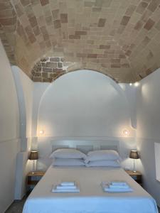 a bedroom with a white bed with a stone ceiling at Casa Vacanze La Quercia in San Vito Chietino