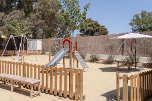 a playground with a slide and an umbrella at TAIGA Almeria Playa in Palomares
