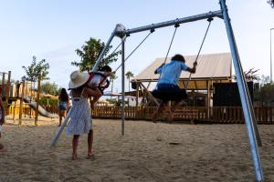 people playing on a swing set at a playground at TAIGA Almeria Playa in Palomares