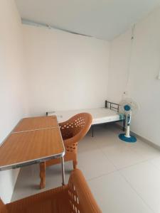 Cette chambre dispose d'une table, d'une chaise et d'un ventilateur. dans l'établissement ALMic INN BOGOR, à Caringin