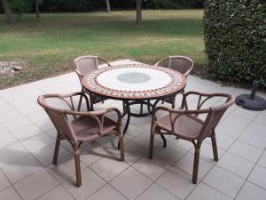 een terrastafel met drie stoelen en een tafel bij Maisonnette drômoise in Châteauneuf-sur-Isère +1 foto