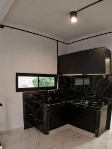 a kitchen with a counter and a window and a sink at Rullah Homestay in Karimunjawa +19 photos