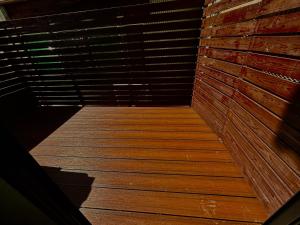 a wooden walkway in a room with a brick wall at Hummingbird Kanazawa in Kanazawa