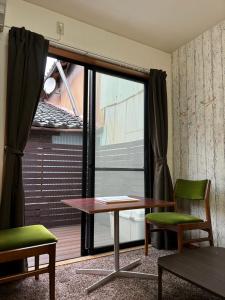 a room with a table and chairs and a window at Hummingbird Kanazawa in Kanazawa