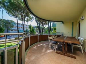 a balcony with a wooden table and chairs at Lignano Riviera Green Lodge in Lignano Sabbiadoro