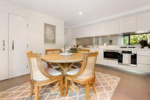 eine Küche mit einem Holztisch und Stühlen in der Unterkunft Vogue charm w light, aspect, AC in Sydney + 8 Fotos