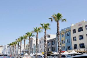 eine Reihe von Palmen auf einem Parkplatz mit Gebäuden in der Unterkunft Vogue charm w light, aspect, AC in Sydney