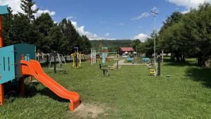 a playground with an orange slide in the grass at Ubytovanie U Mirca in Nová ľubovňa