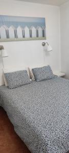 Un dormitorio con una cama con dos almohadas azules. en Casa da Tia, en Ferrel