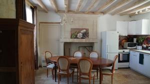 a dining room with a table and chairs and a kitchen at Gîte Aliénor en Anjou in Vernoil