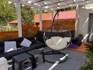 a hanging chair on a patio with a couch at Apartman Žanić Crikvenica with Hot tub in Crikvenica
