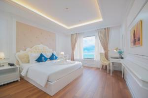 a white bedroom with a large bed and a window at Sea Soul Hotel in Nha Trang