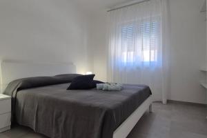 biała sypialnia z dużym łóżkiem i oknem w obiekcie Le Dimore di Donato w mieście Torre San Giovanni Ugento