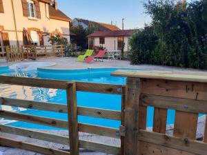 a wooden fence next to a swimming pool at Gite meublé et Chambre d'hôtes LE PUITS DARCY in Montceau-les-Mines