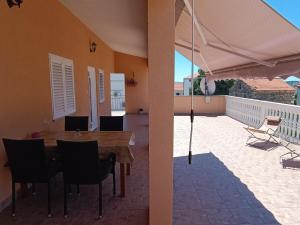 a table and chairs and an umbrella on a patio at Apartmani Šprljan in Vodice