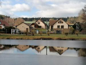 a group of houses next to a body of water at Apartments 2 Ubytování u kostela, Sedlo in Číměř