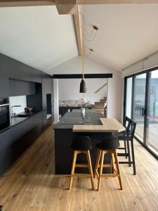 a kitchen with a large island with chairs and a table at Villa des Loriots in Anglet