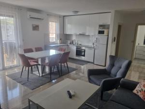 a kitchen and living room with a table and chairs at Exclusive Kiseljak apartman in Kiseljak