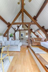 ein Wohnzimmer mit weißen Möbeln und Holzdecken in der Unterkunft Le Cottage à 10min de Disneyland Paris in Chalifert