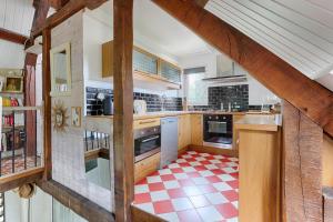 eine Küche mit einem roten und weißen karierten Boden in der Unterkunft Le Cottage à 10min de Disneyland Paris in Chalifert