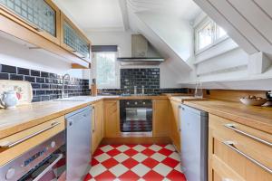 eine Küche mit einem roten und weißen karierten Boden in der Unterkunft Le Cottage à 10min de Disneyland Paris in Chalifert