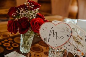 a table with two vases with roses and a me sign at Casa din Valea Bucovinei in Valea Moldovei